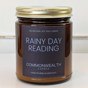 Candle jar labeled 'Rainy Day Reading' by Commonwealth Candle on a light background