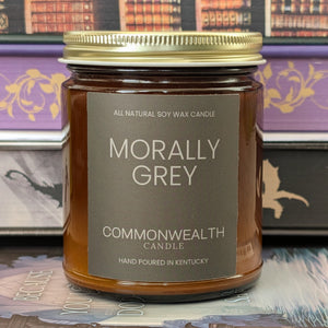 Candle jar labeled 'Morally Grey' by Commonwealth Candle on a decorative background.
