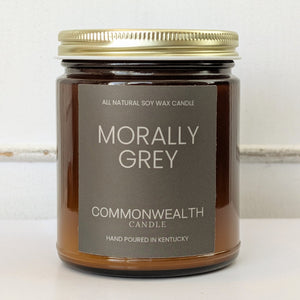 Candle jar labeled 'Morally Grey' by Commonwealth Candle on a light background
