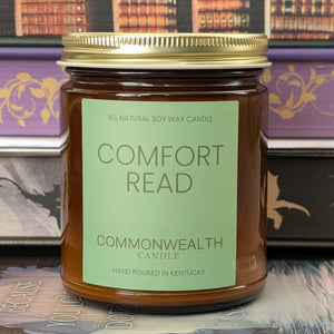 Jar of 'Comfort Read' candle by Commonwealth Candle on a bookshelf background