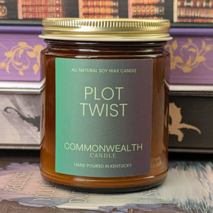 Jar of 'Plot Twist' candle by Commonwealth Candle on a bookshelf background